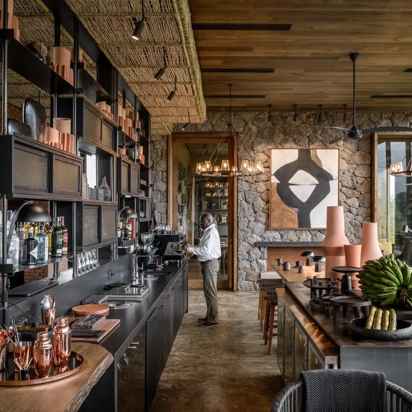 Modern lounge interior with stone walls and countryside views, Singita Kwitonda Lodge, Volcanoes National Park, Rwanda