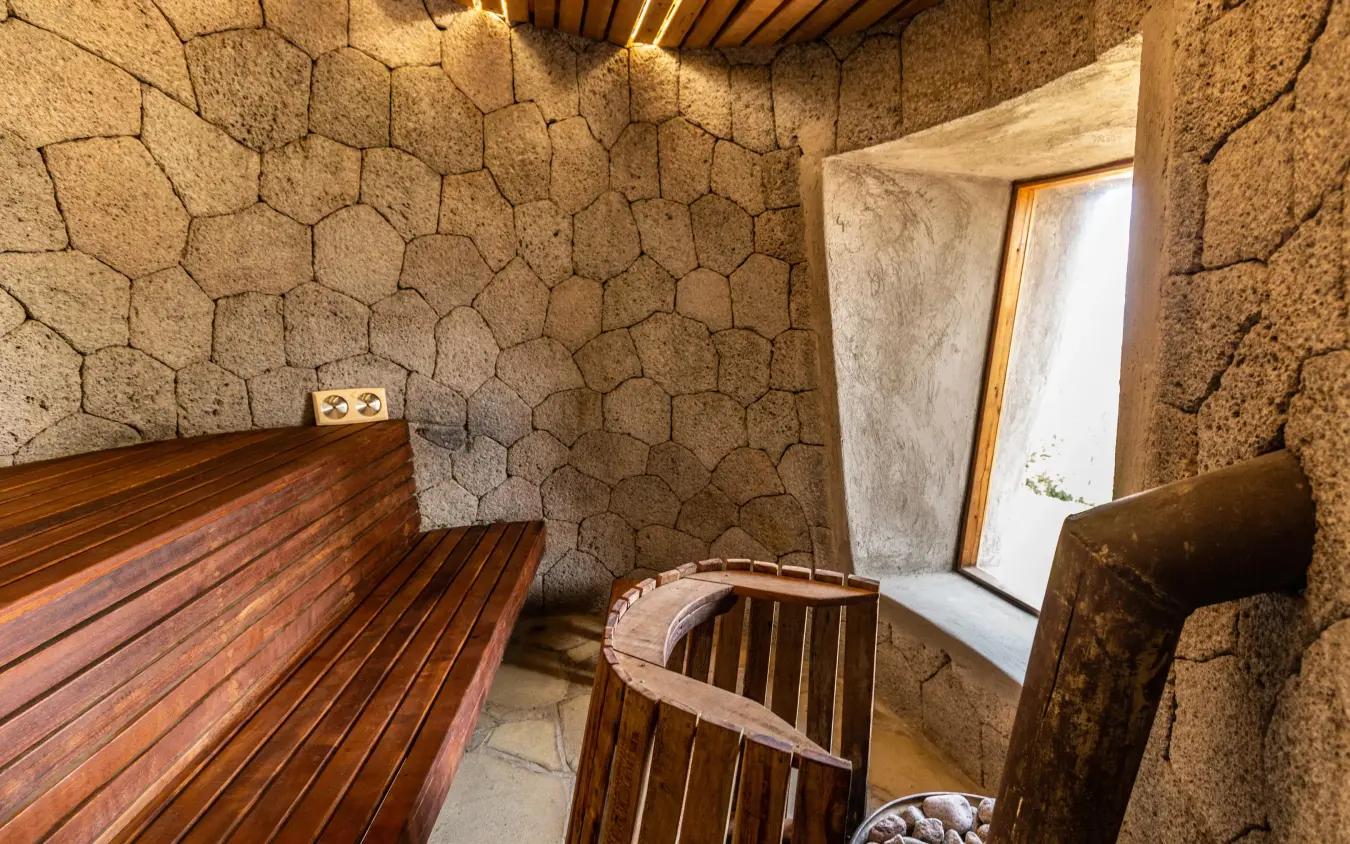 Interior sauna room with wooden benches and stone walls, Virunga Lodge, Volcanoes National Park, Rwanda