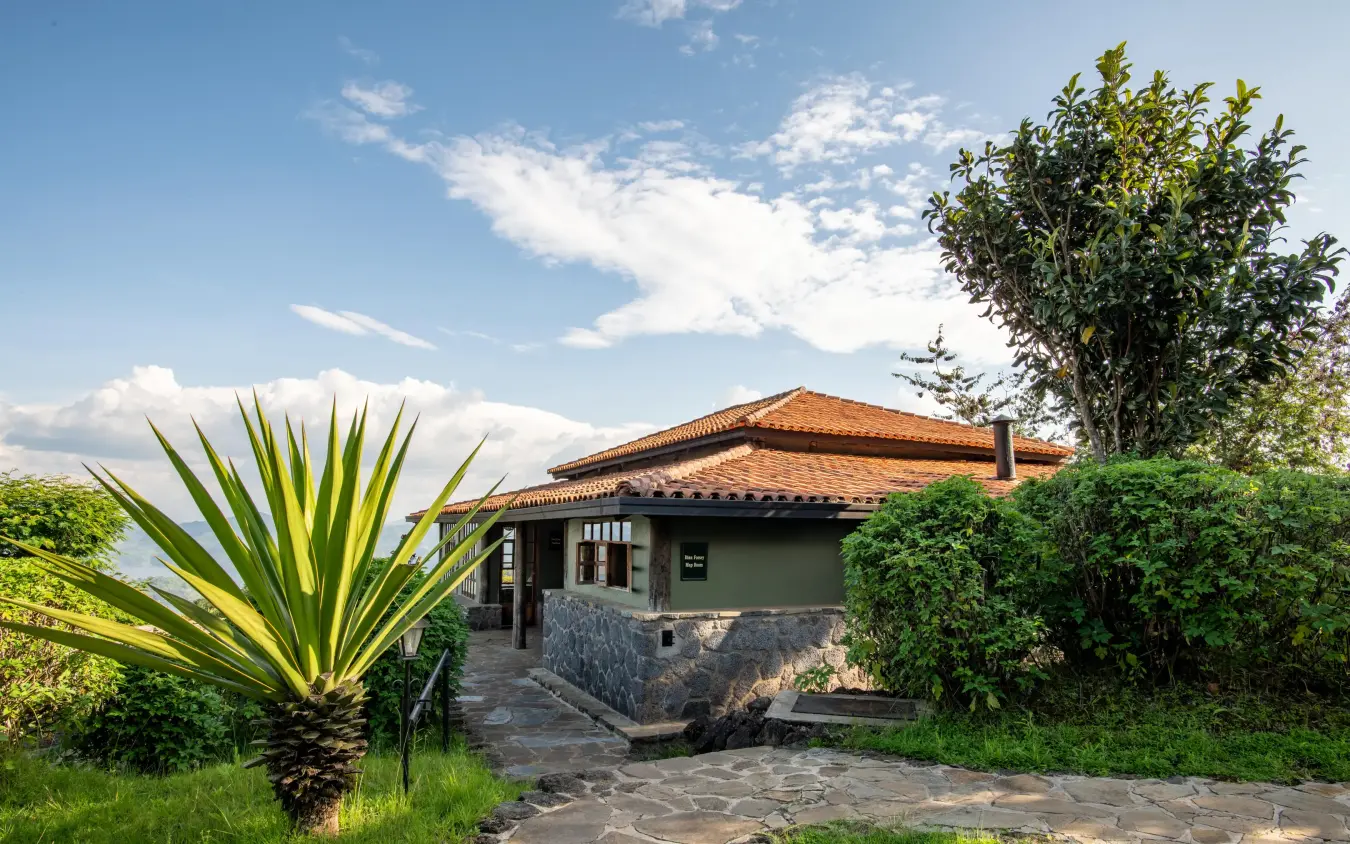 Stone pathway leading to colonial-style lodge building with terracotta roof, Virunga Lodge, Volcanoes National Park, Rwanda