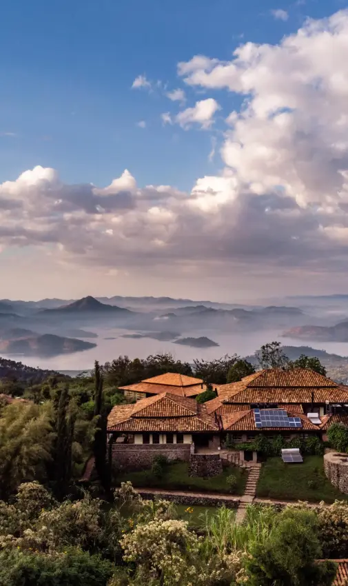 Terracotta-roofed lodge nestled in misty mountain valley, Virunga Lodge, Volcanoes National Park, Rwanda