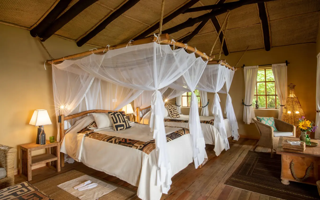 Spacious bedroom with four-poster canopy bed and wooden beams, Virunga Lodge, Volcanoes National Park, Rwanda