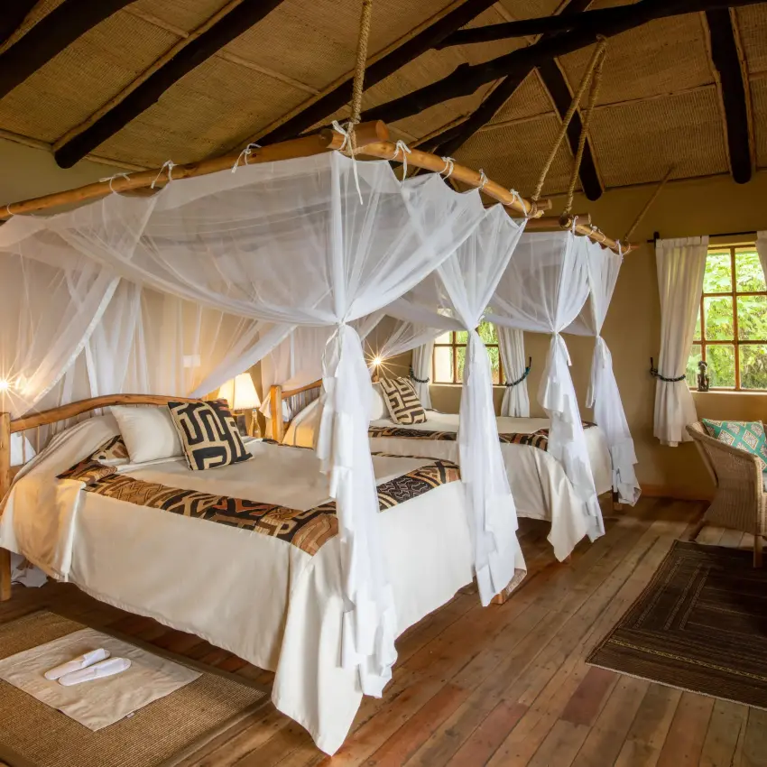 Spacious bedroom with four-poster canopy bed and wooden beams, Virunga Lodge, Volcanoes National Park, Rwanda