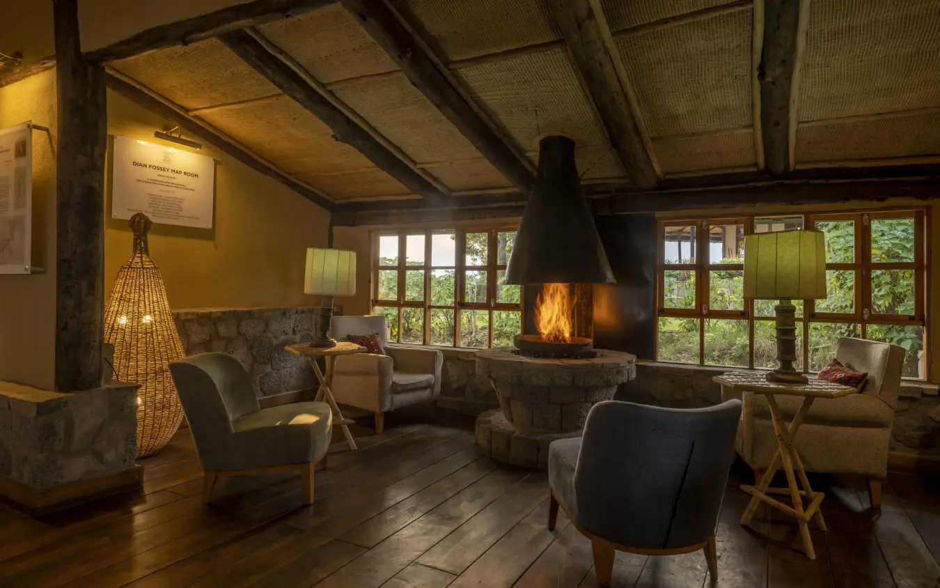 Interior lounge with fireplace, seating areas, and large windows, Virunga Lodge, Volcanoes National Park, Rwanda