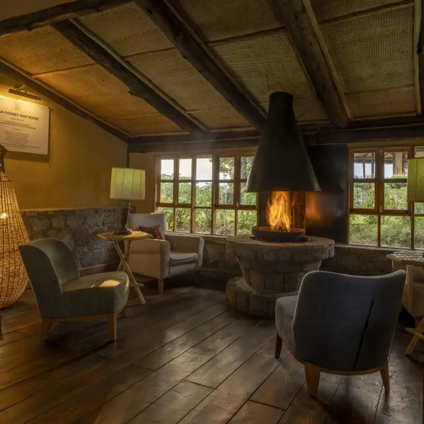 Interior lounge with fireplace, seating areas, and large windows, Virunga Lodge, Volcanoes National Park, Rwanda