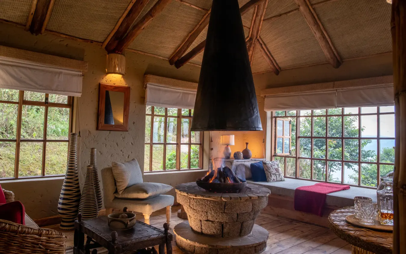 Central fireplace lounge with large windows overlooking landscape, Virunga Lodge, Volcanoes National Park, Rwanda