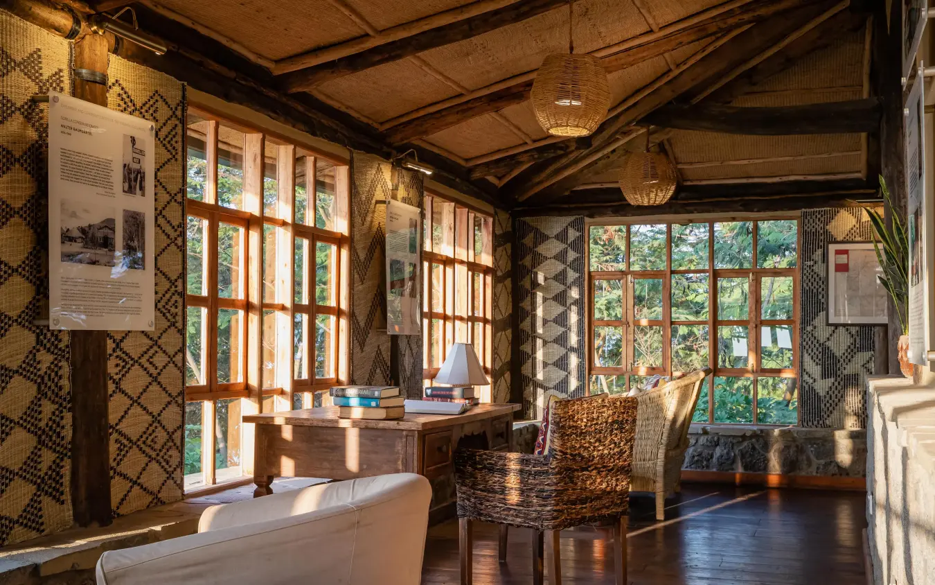 Interior lounge with wooden beams and large windows overlooking greenery, Virunga Lodge, Volcanoes National Park, Rwanda