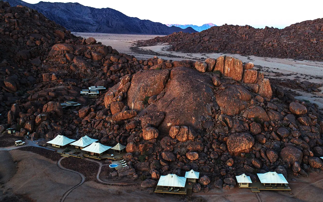 Boulder camp with white tents nestled among rocky outcrops, Wolwedans Boulders Camp, NamibRand Private Reserve, Namibia