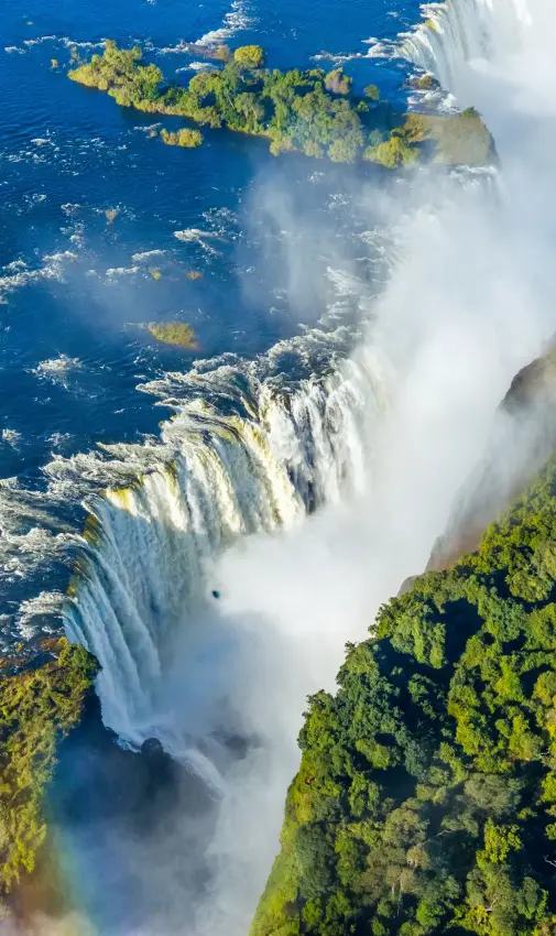 Aerial view of massive waterfall cascading into river below