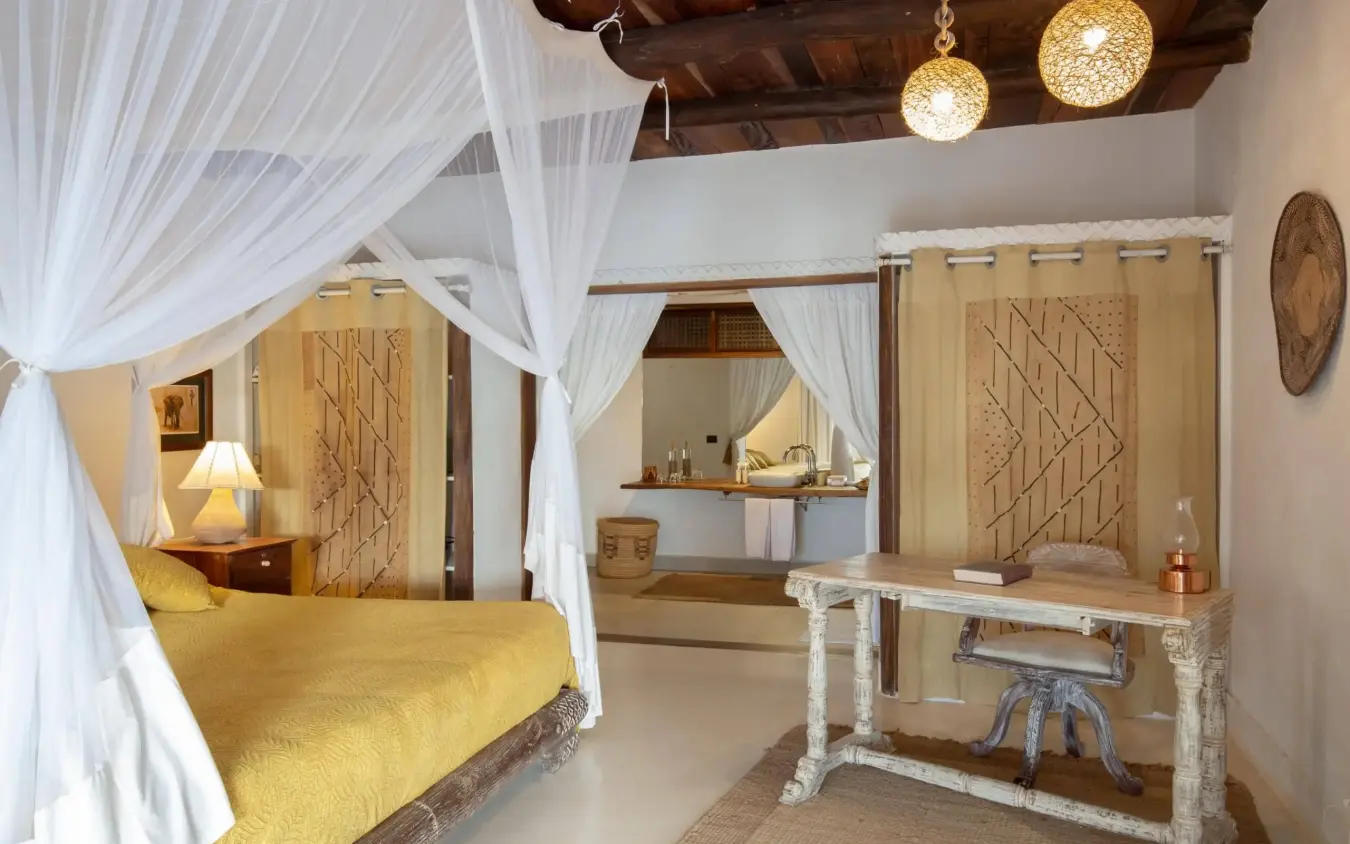 Luxury bedroom suite with four-poster bed and white sheer drapes, Alfajiri Beach Villa, Diani Beach, Kenya