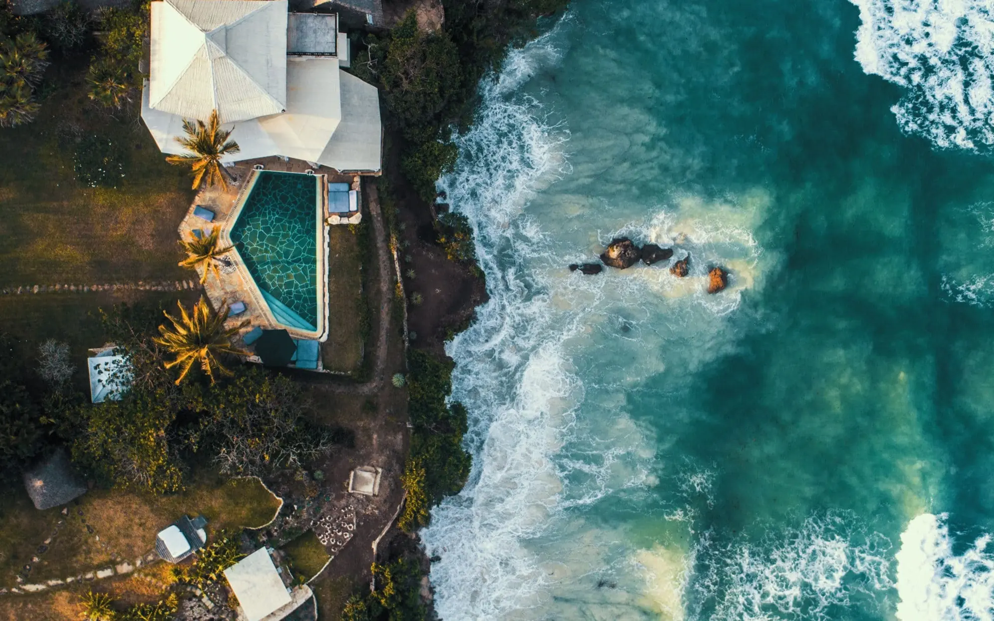 Clifftop villa with infinity pool overlooking ocean waves and rocky coastline, Alfajiri Cliff Villa, Diani Beach, Kenya