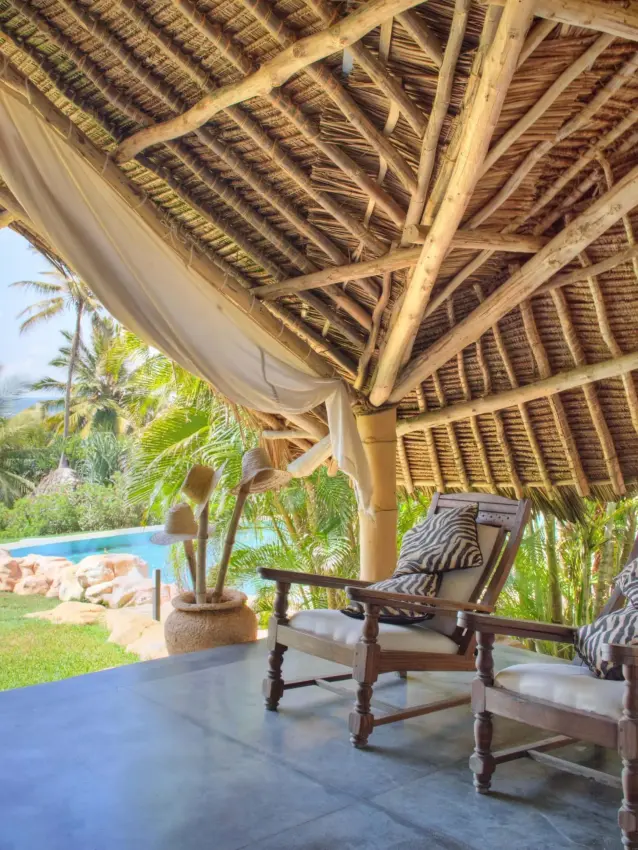Thatched pavilion with zebra-print chairs overlooking pool and tropical gardens, Alfajiri Garden Villa, Diani Beach, Kenya