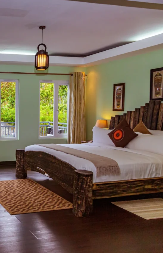 Spacious bedroom with wooden bed and garden views, Amakoro Songa Lodge, Volcanoes National Park, Rwanda