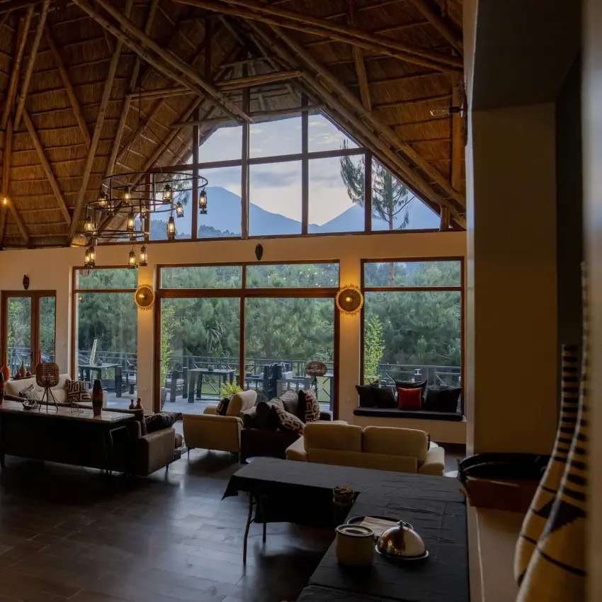 Open-plan lodge interior with mountain views through large windows, Amakoro Songa Lodge, Volcanoes National Park, Rwanda