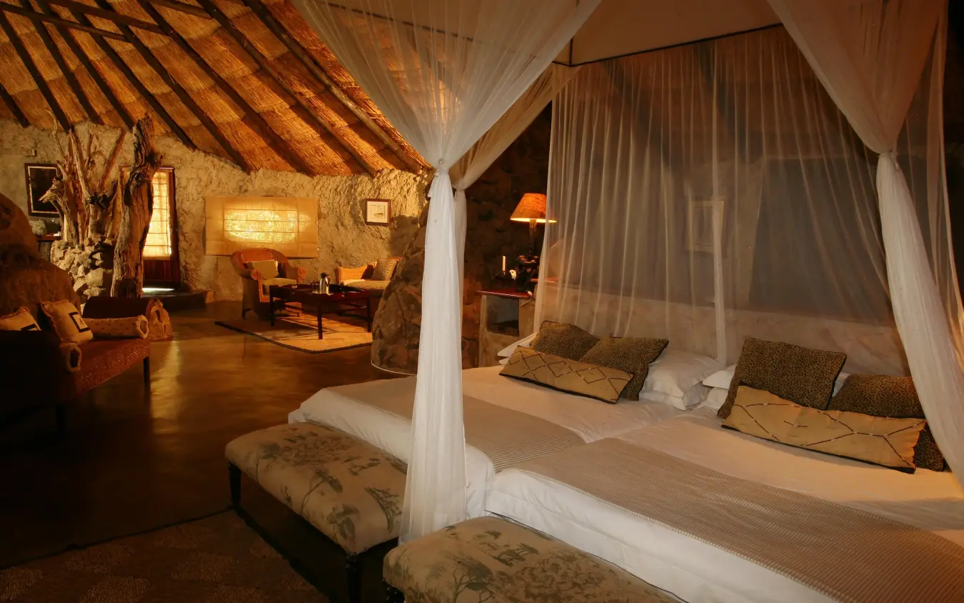 Luxury bedroom suite with four-poster bed and sitting area, Amalinda Lodge, Matobo, Zimbabwe