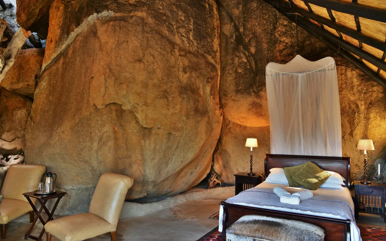 Bedroom with large natural boulder as headboard feature, Amalinda Lodge, Matobo, Zimbabwe