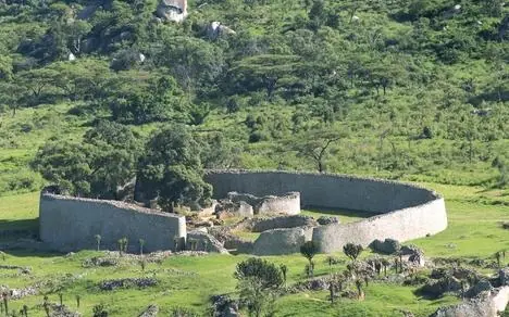 Stone lodge compound surrounded by lush green hillside forest, Amalinda Lodge, Matobo, Zimbabwe