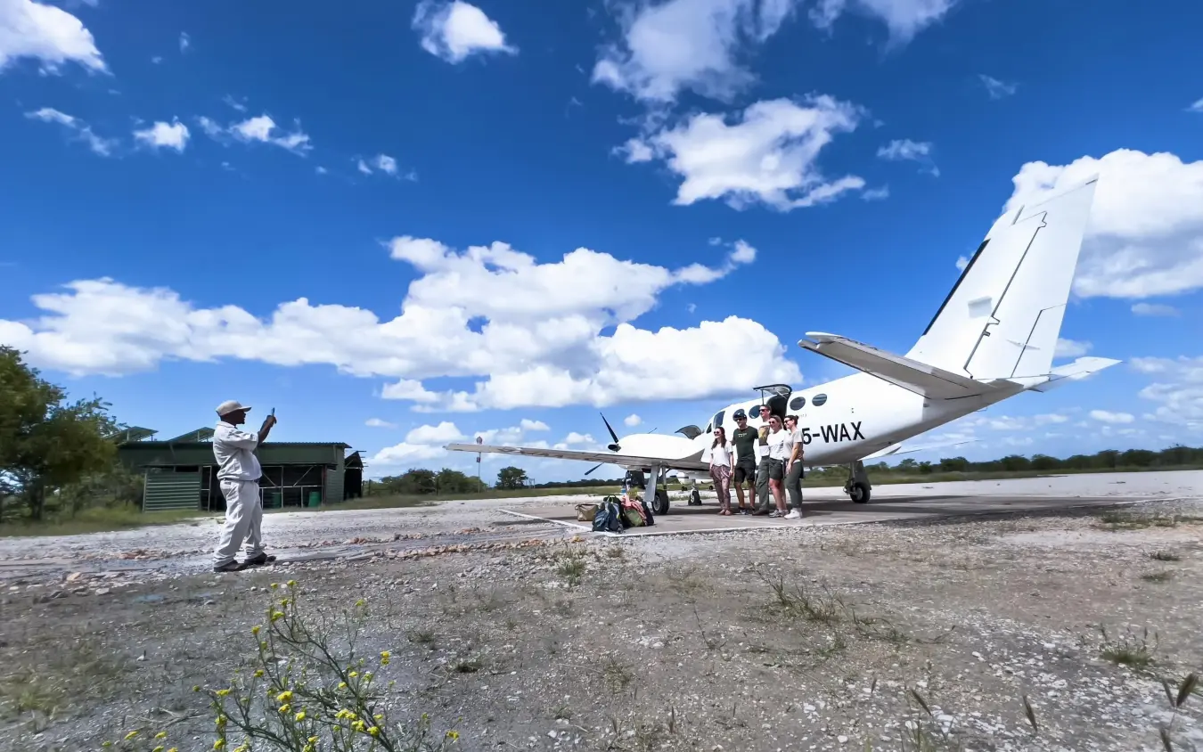 Small aircraft landing at remote airstrip in African savanna, Anderssons at Ongava, Etosha National Park, Namibia