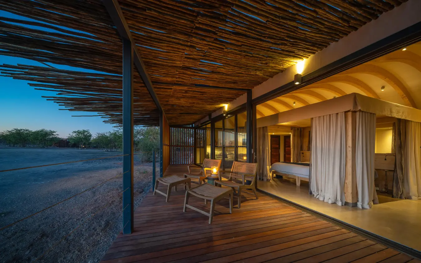 Wooden deck with seating overlooking savanna at dusk, Anderssons at Ongava, Etosha National Park, Namibia