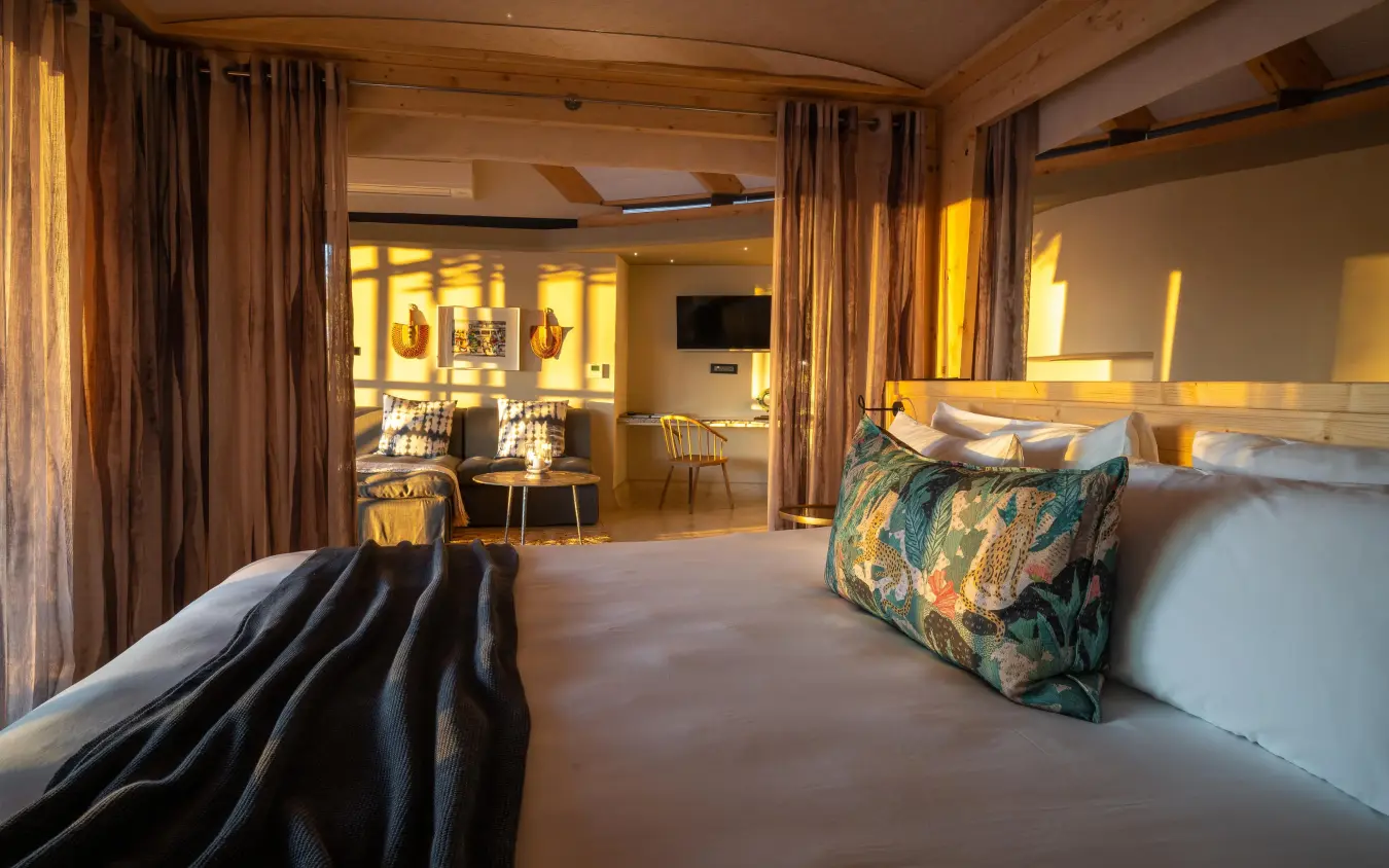Spacious bedroom with open-plan living area and warm lighting, Anderssons at Ongava, Etosha National Park, Namibia