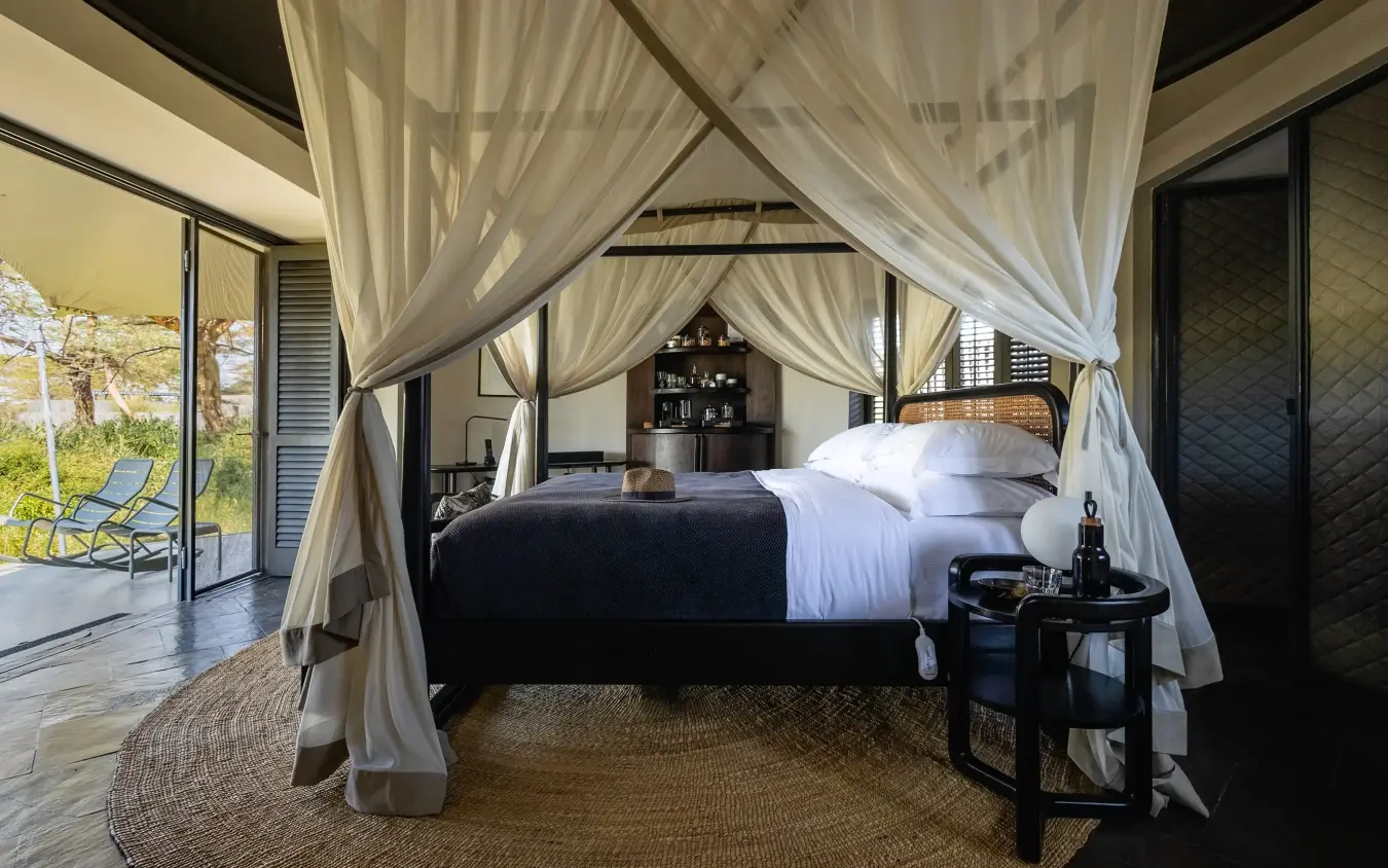Luxury canopy bed with sheer curtains in safari lodge bedroom suite, Angama Amboseli, Amboseli and Chyulu Hills, Kenya