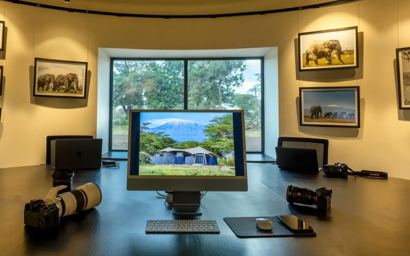 Photographer's studio workspace displaying safari and wildlife imagery, Angama Amboseli, Amboseli and Chyulu Hills, Kenya