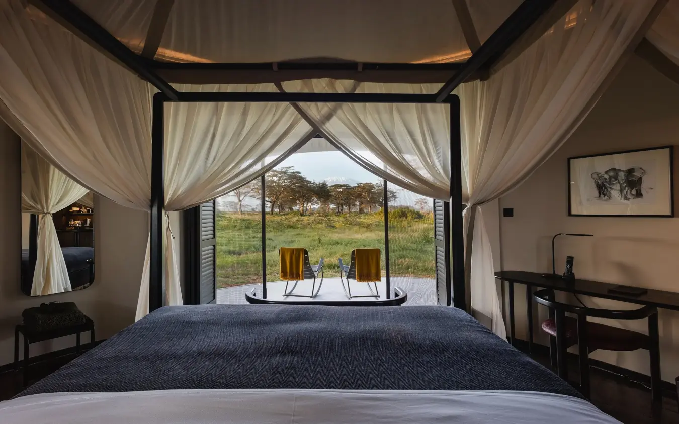 Luxury safari tent bedroom with open views across grassland savanna, Angama Amboseli, Amboseli and Chyulu Hills, Kenya