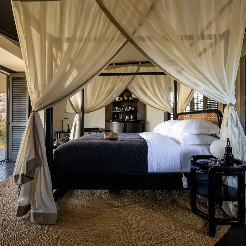 Four-poster canopy bed in luxury safari suite with open veranda view, Angama Amboseli, Amboseli and Chyulu Hills, Kenya