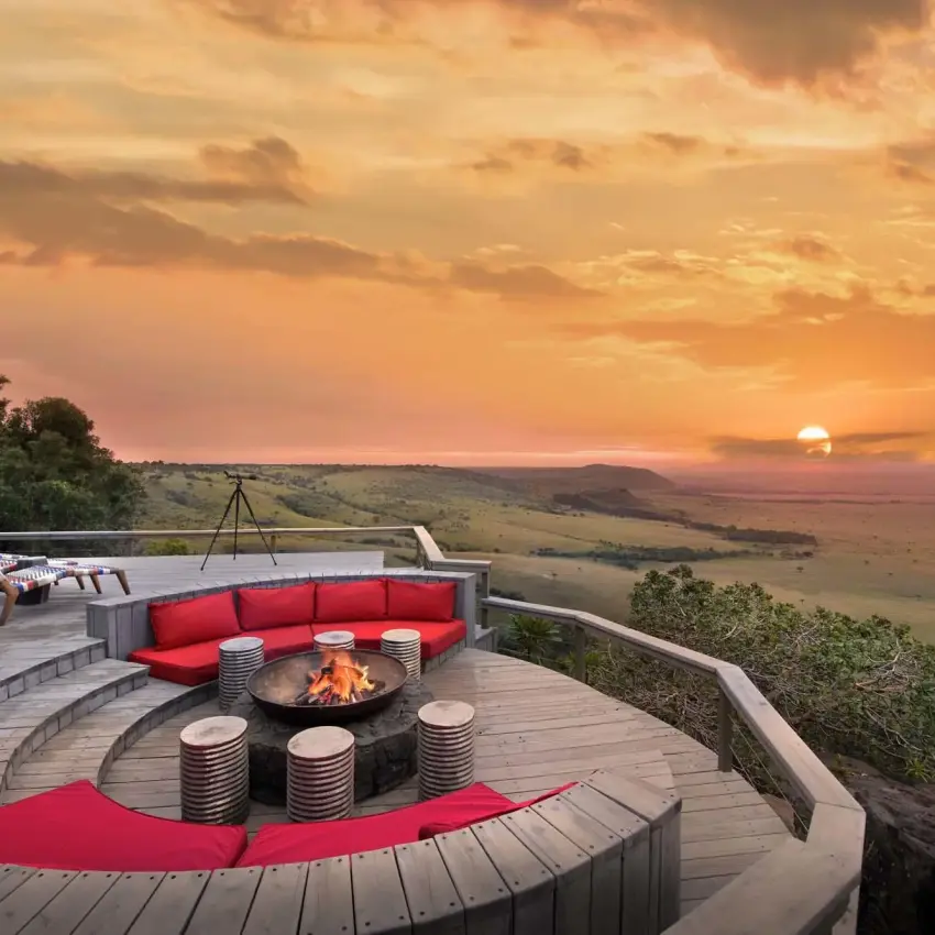 Curved wooden deck with fire pit overlooking savanna at sunset, Angama Mara, Maasai Mara, Kenya