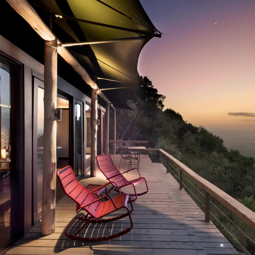 Sunset view from elevated deck with lounge chairs, Angama Mara, Maasai Mara, Kenya