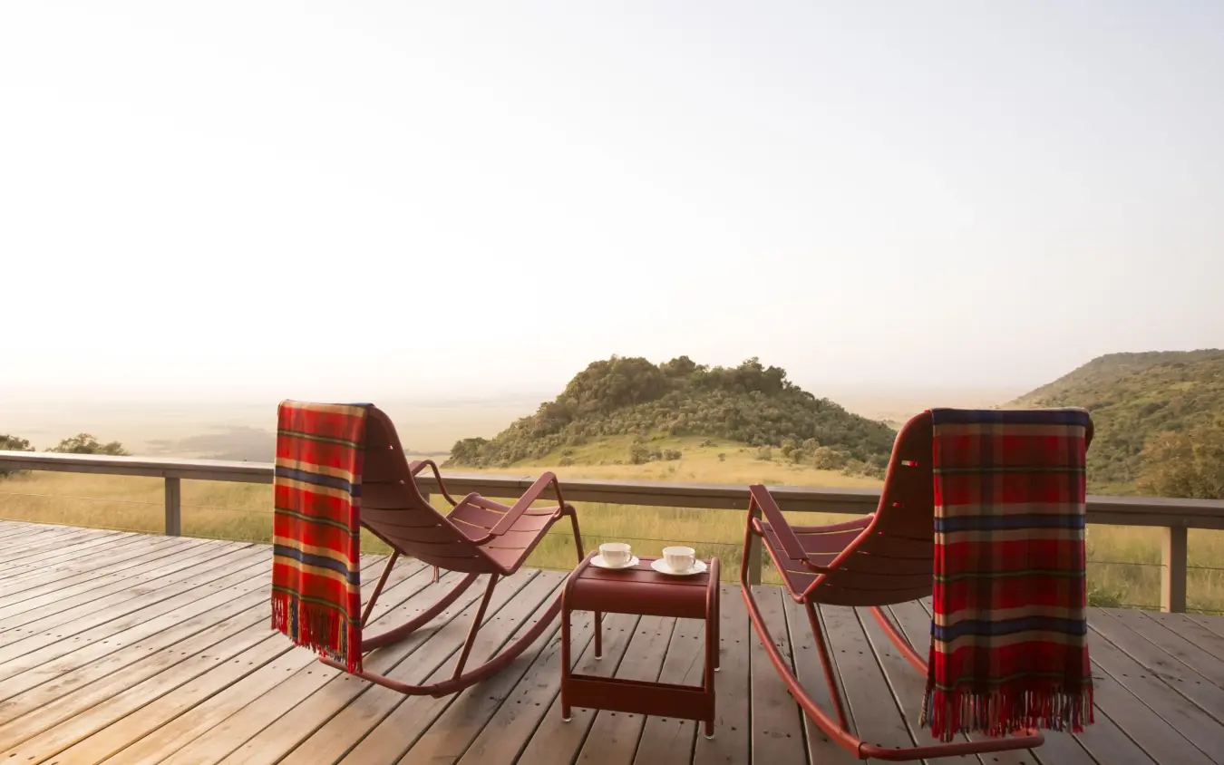 Wooden deck with chairs overlooking savanna valley landscape, Angama Mara, Maasai Mara, Kenya