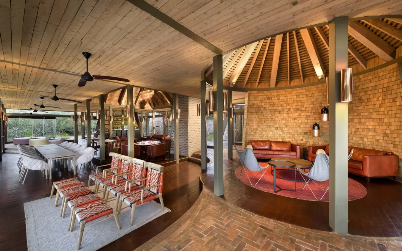 Open-plan lounge with brick walls and wooden ceiling, Angama Mara, Maasai Mara, Kenya