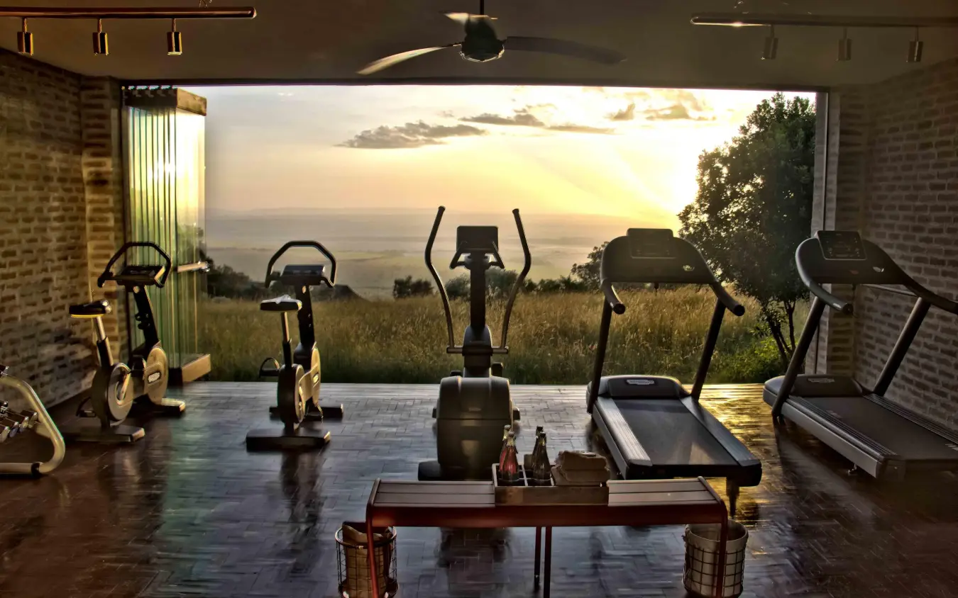 Fitness studio with exercise equipment overlooking savanna landscape, Angama Mara, Maasai Mara, Kenya
