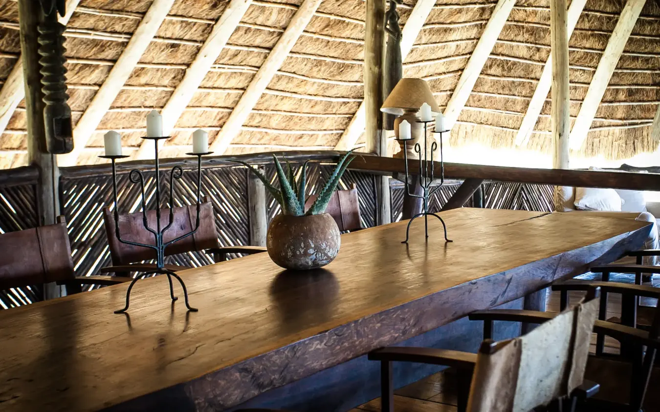 Open-air lounge with thatched roof and wooden dining table, Apoka Safari Lodge, Kidepo Valley, Uganda