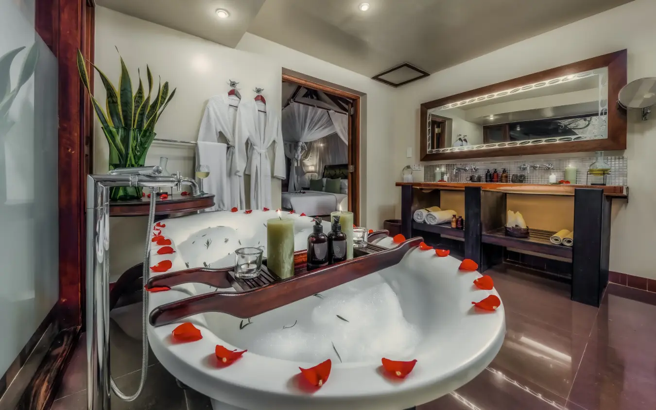 Luxury bathroom with sunken bathtub decorated with flower petals, Arusha Coffee Lodge, Arusha, Tanzania
