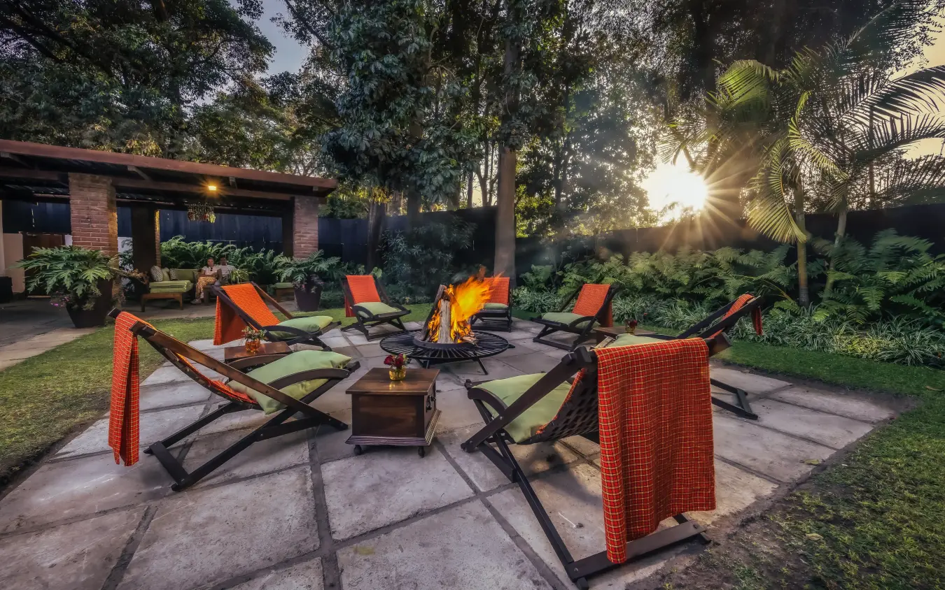 Outdoor fire pit lounge with canvas chairs at dusk, Arusha Coffee Lodge, Arusha, Tanzania