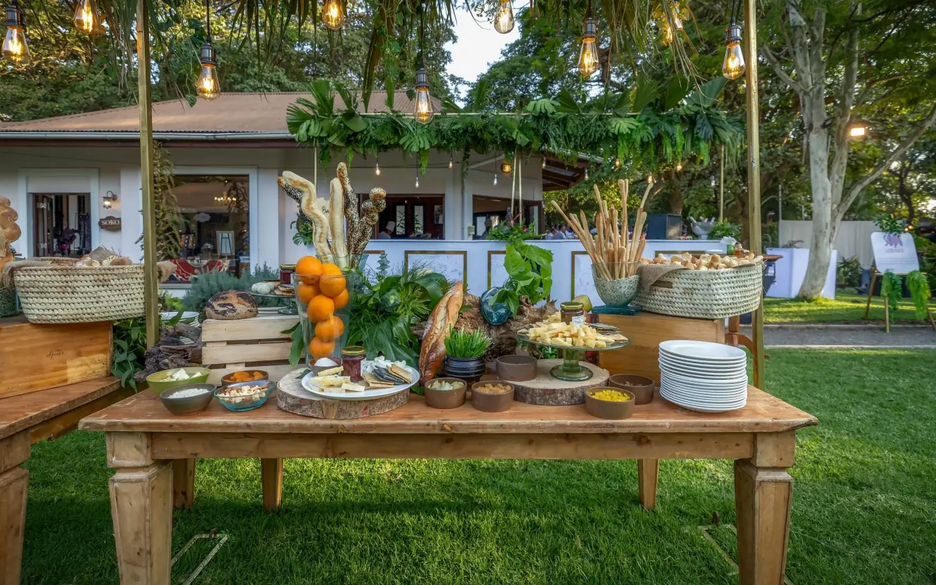 Outdoor dining table with fresh produce and tableware under thatched pavilion, Arusha Coffee Lodge, Arusha, Tanzania