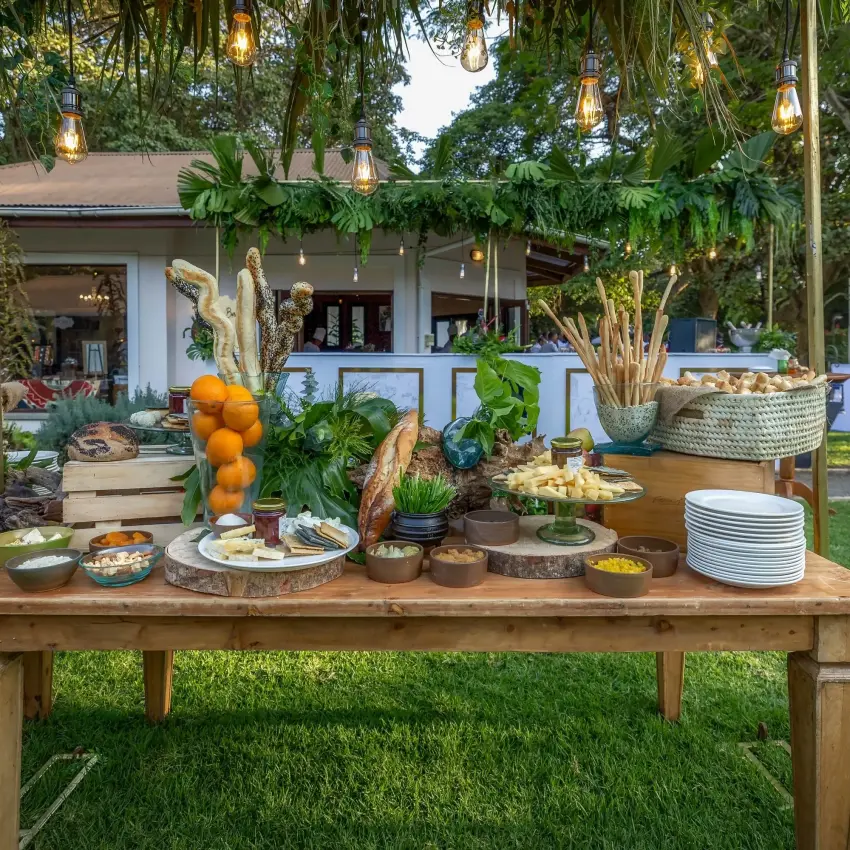 Outdoor dining table with fresh produce and tableware under thatched pavilion, Arusha Coffee Lodge, Arusha, Tanzania