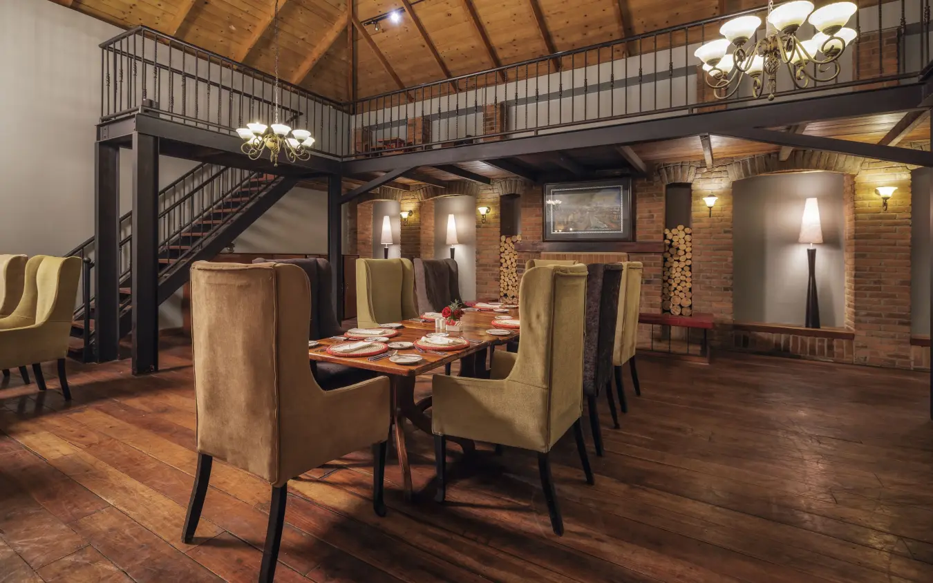 Brick loft dining room with mezzanine level and fireplace, Arusha Coffee Lodge, Arusha, Tanzania