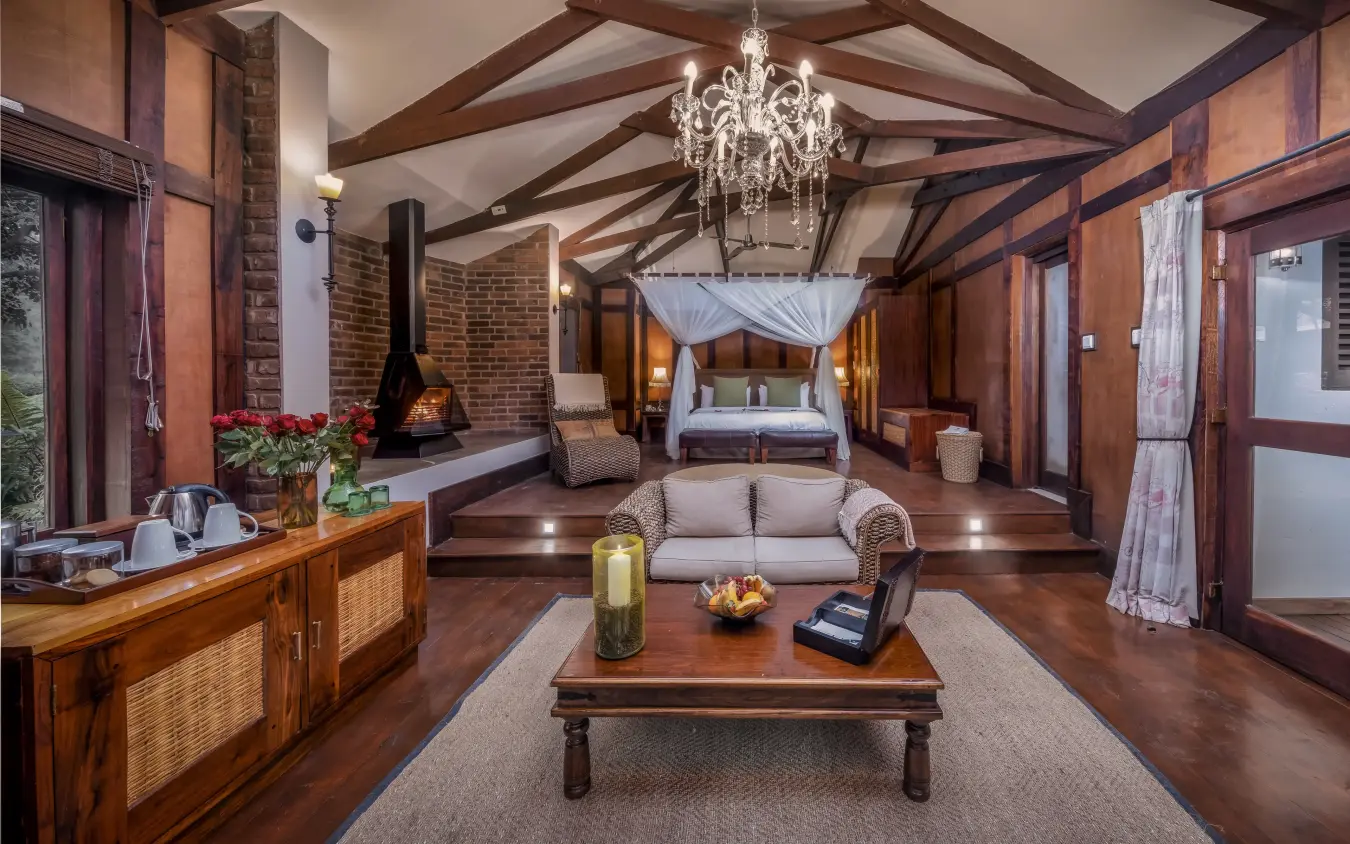Luxury safari lodge interior with fireplace, chandelier and canopied bed, Arusha Coffee Lodge, Arusha, Tanzania