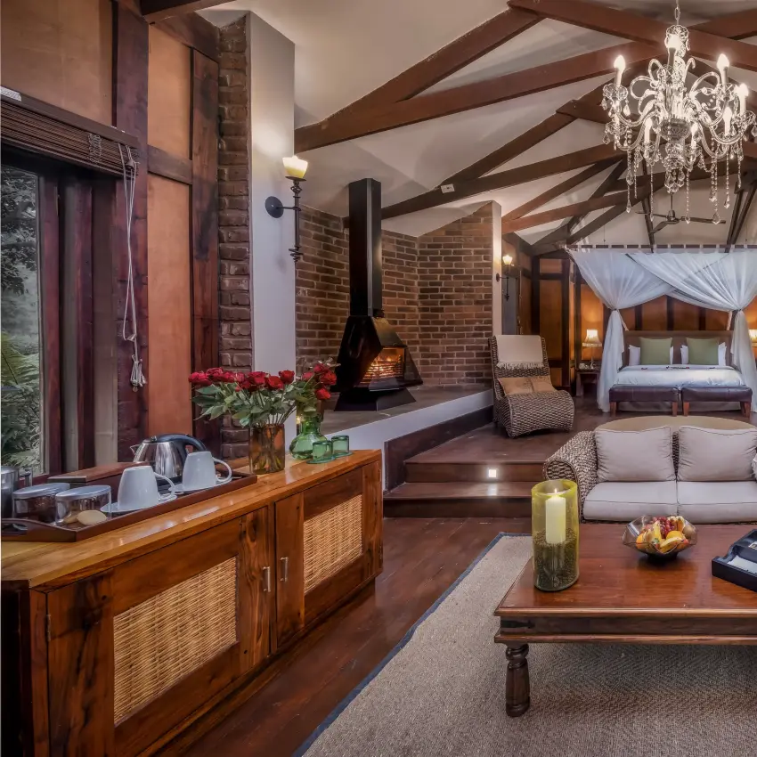 Luxury safari lodge interior with fireplace, chandelier and canopied bed, Arusha Coffee Lodge, Arusha, Tanzania