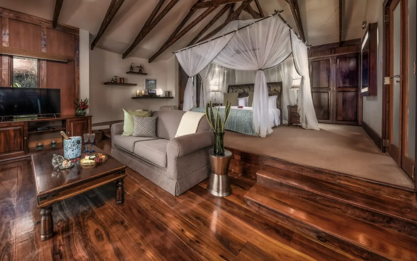 Luxury bedroom suite with canopied bed and lounge seating area, Arusha Coffee Lodge, Arusha, Tanzania