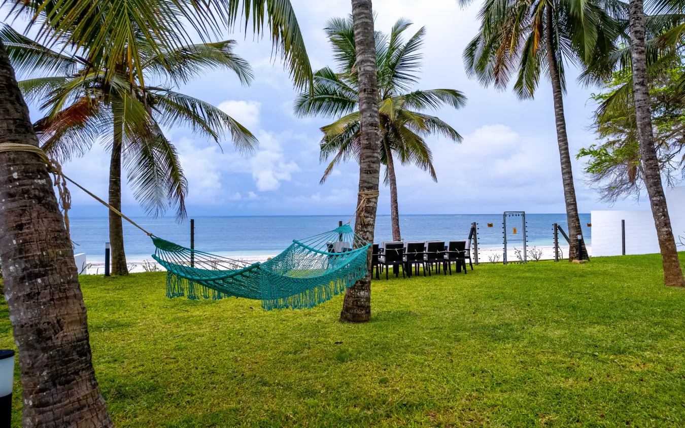 Hammock strung between palm trees on beachfront lawn with ocean view, Bahari Bliss, Kilifi, Kenya