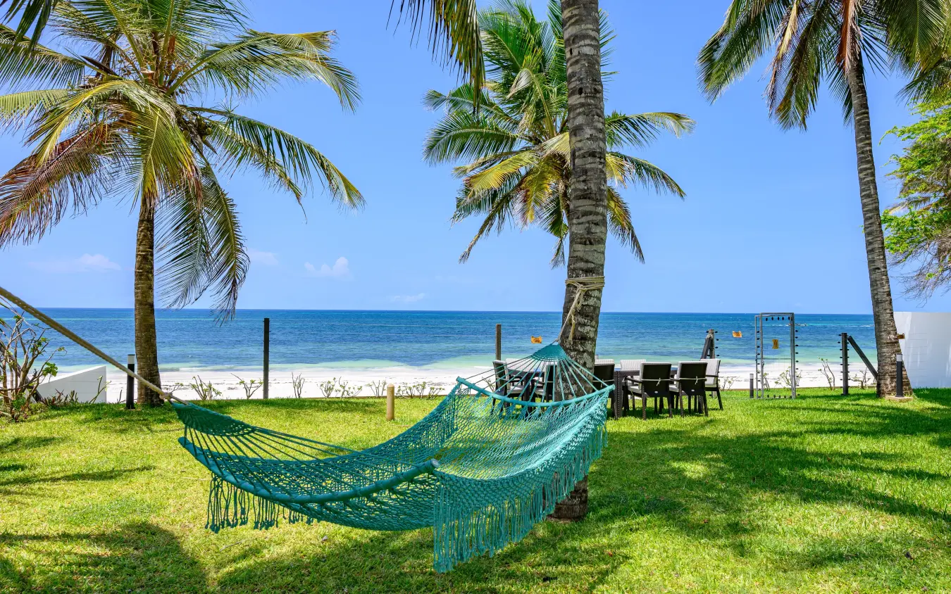 Turquoise hammock on beachfront lawn beneath palm trees overlooking ocean, Bahari Bliss, Kilifi, Kenya