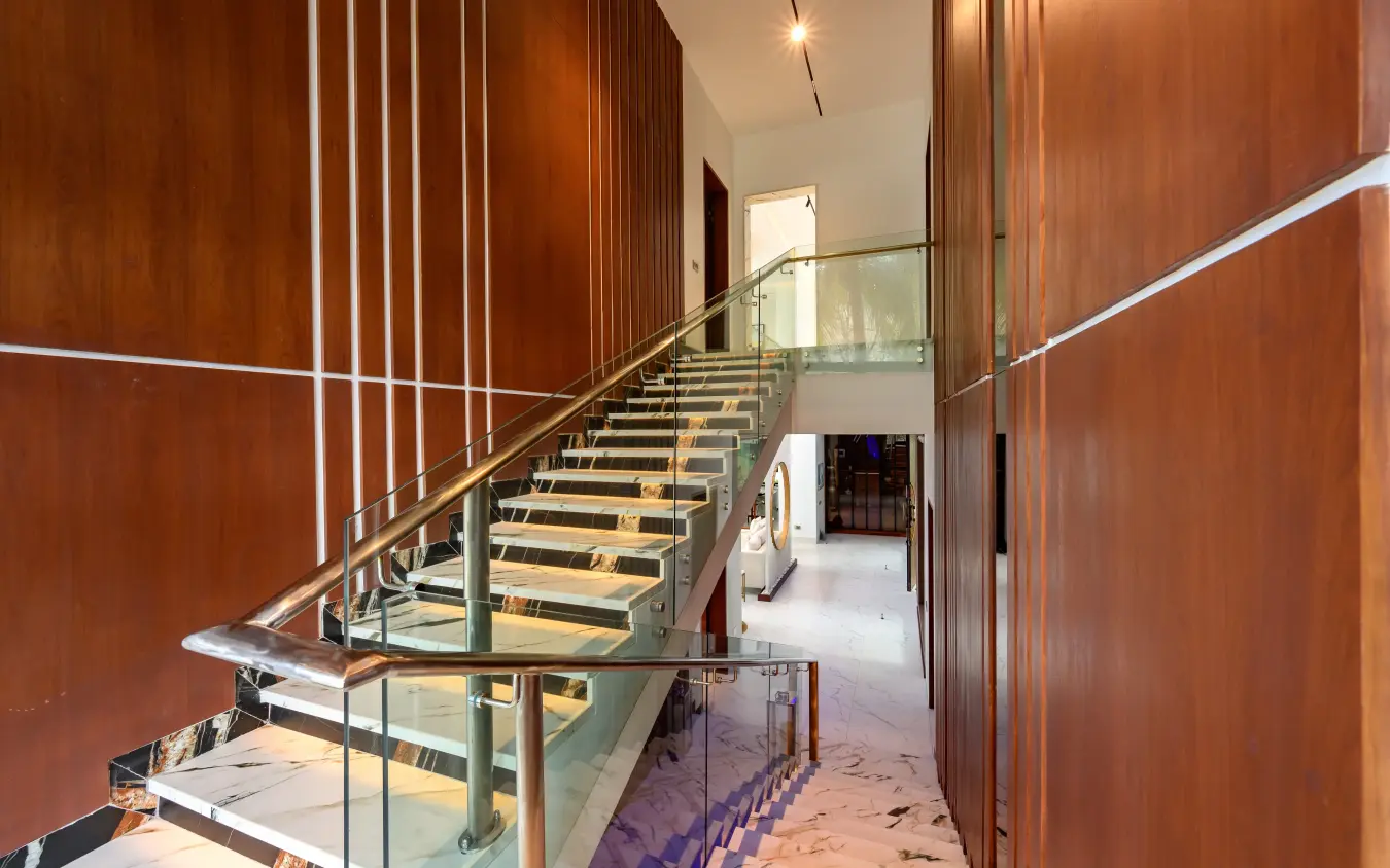 Modern staircase with wood paneling and glass railings in contemporary building interior, Bahari Bliss, Kilifi, Kenya
