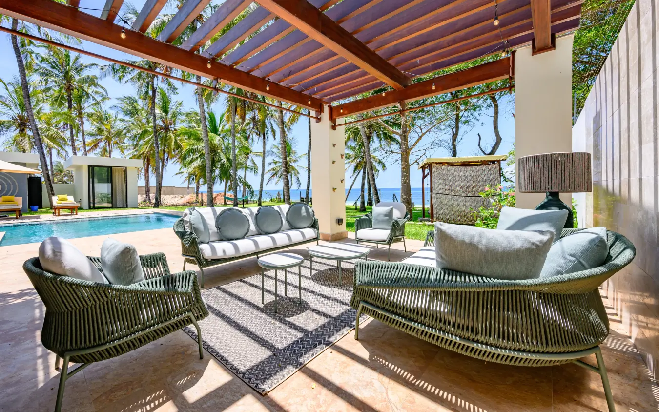 Beachfront lounge with woven chairs and ocean view through timber pergola, Bahari Bliss, Kilifi, Kenya