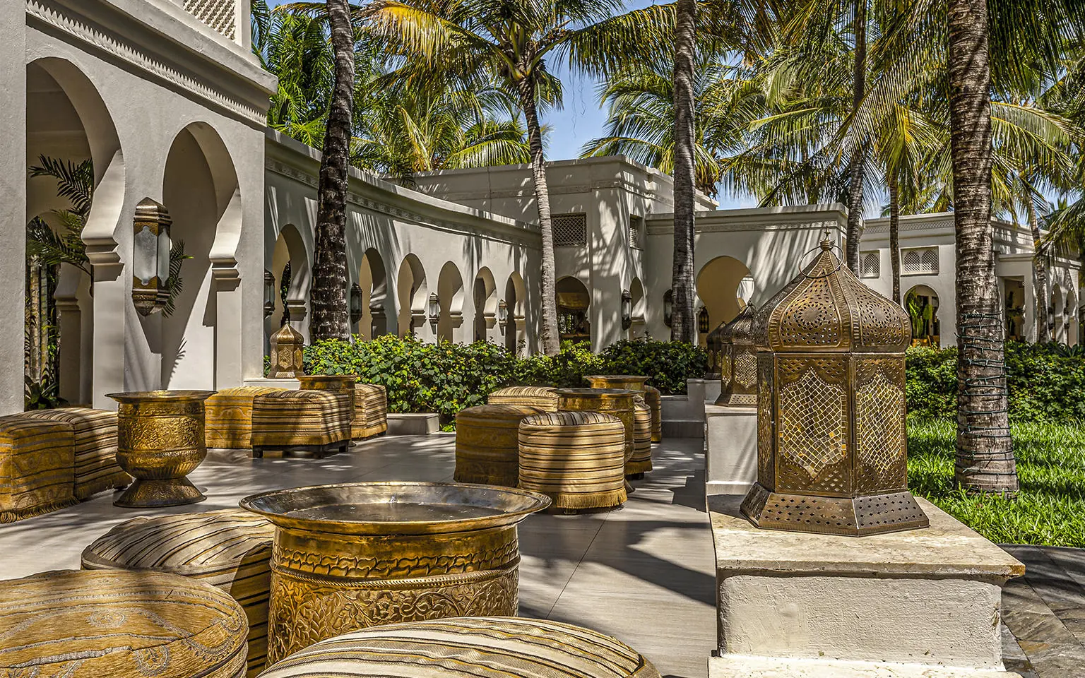 Courtyard with ornate brass vessels and palm trees, Baraza Resort and Spa, Zanzibar & Pemba, Tanzania