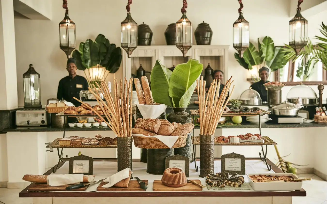 Elegant buffet spread with breads, fresh plants and pendant lighting, Baraza Resort and Spa, Zanzibar & Pemba, Tanzania