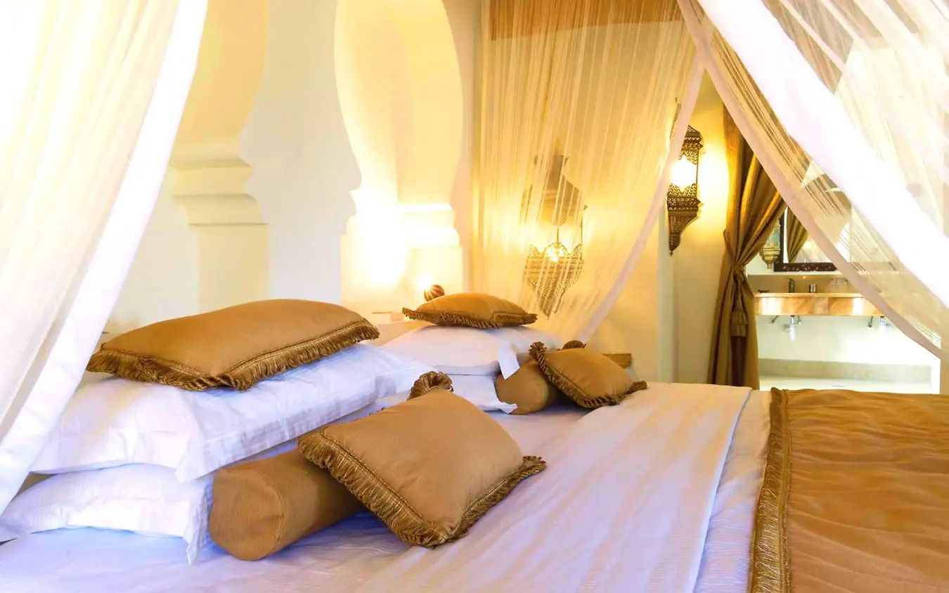 Bedroom with canopy beds and gold decorative pillows, Baraza Resort and Spa, Zanzibar & Pemba, Tanzania