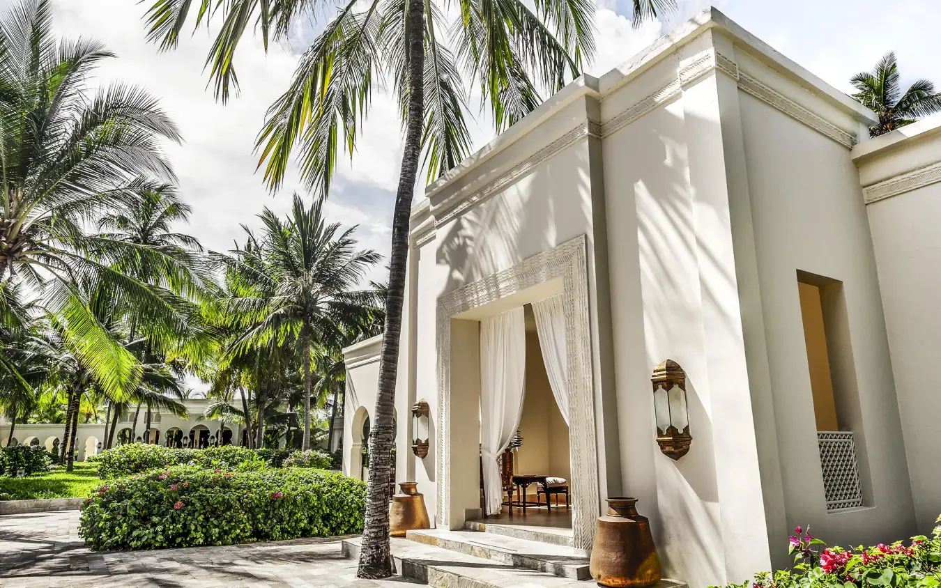 White villa with palm trees and manicured gardens pathway, Baraza Resort and Spa, Zanzibar & Pemba, Tanzania