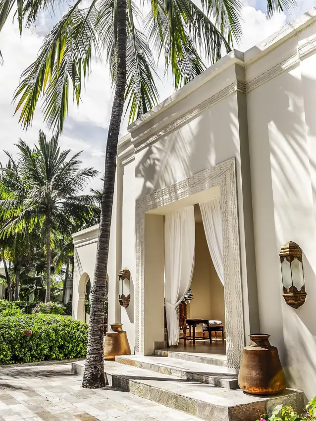 White villa with palm trees and manicured gardens pathway, Baraza Resort and Spa, Zanzibar & Pemba, Tanzania
